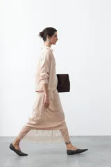 Falda midi negra de caída fluida con cintura elastizada y un amplio detalle de encaje negro en el bajo.