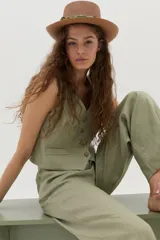 Pantalón de lino color beige, de corte ancho y relajado, con cintura alta y bolsillos laterales.