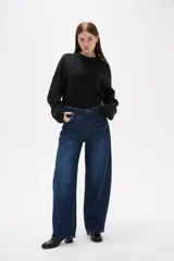 Pantalon jean de corte barrel y tiro medio, en color negro, con diseño de pierna ancha y estructura rígida.