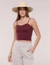 Top crop ajustado negro de estilo corsé, con tirantes finos regulables y escote corazón. Cuenta con costuras verticales decorativas en el frente.