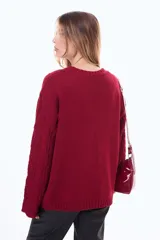 Buzo tejido de punto con diseño de trenzas, color negro, de corte holgado, cuello redondo y mangas largas.