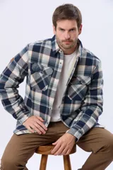 Campera leñadora de viyela a cuadros en tonos beige y azul oscuro, con interior forrado en corderito, cierre frontal con botones y dos bolsillos con solapa en el pecho.