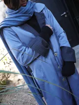 Impermeable color beige con cuello clásico, cierre con botones y cinturón. Detalles en tweed en puños y solapa.