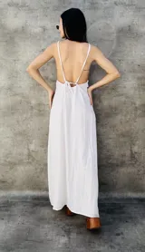 Vestido largo blanco con espalda descubierta y tirantes finos que se atan en la parte superior de la espalda.