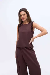 Musculosa negra con cuello redondo y detalles de volados en los hombros, confeccionada en una mezcla de algodón y Tencel.