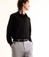 Camisa masculina de manga larga, cuello inglés y cierre frontal de botones, confeccionada en poliamida con elastano y tecnología performance.