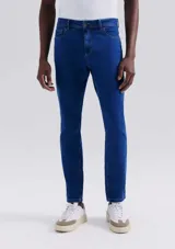 Pantalón de jean de corte slim, color azul, con cierre de botón y cremallera, y bolsillos laterales y traseros.