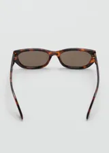 Lentes de sol con armazón de carey y diseño rectangular, con cristales oscuros.