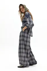 Pantalón de corte culotte con diseño de cuadros, cintura alta con pinzas, cierre frontal y piernas anchas.