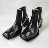 Bota tipo chelsea de cuero negro con detalles de costuras en blanco, puntera cuadrada y taco bloque.