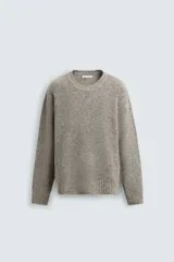 Jersey de punto perlado con ajuste relajado, cuello redondo y manga larga, con acabados en rib en puños y cintura.