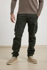 Pantalón cargo verde oscuro con bolsillos laterales y traseros con solapa.