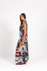 Vestido largo sin mangas de cuello alto, con estampa abstracta multicolor, volados en las mangas y falda con volado inferior.