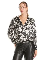 Blusa de satén con estampado floral en blanco y negro, con cuello solapa, escote en V y diseño cruzado. Presenta mangas largas con puños abotonados y ruedo con frunce elástico.