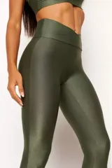 Calza deportiva negra de tiro alto con cintura cruzada en forma de V y tejido texturizado acanalado con brillo.