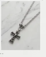 Collar de acero italiano con dije de cruz grande decorado con múltiples calaveras en relieve y dos calaveras adicionales en la unión de la cadena.