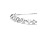 Pulsera plateada con cristales blancos redondos engarzados en bisel. Tiene un cierre deslizante que permite ajustarla a la muñeca.