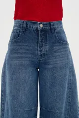 Pantalón de jean blanco de tiro medio, con diseño de silueta barrel, bolsillos clásicos y costuras con pinzas decorativas en la zona de las rodillas.