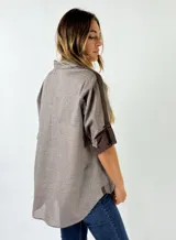 Camisa celeste de algodón con mangas 3/4 y puños marrones.