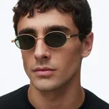 Lentes de sol con montura ovalada de acero inoxidable en color dorado y lentes polarizadas en tono verde oliva. Presentan un diseño minimalista con patillas de terminación en acetato.
