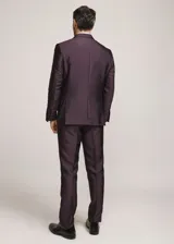 Traje formal de tres piezas en tono tostado brillante, compuesto por saco con solapas en contraste, pantalón de corte recto y chaleco a juego, acompañado de moño.