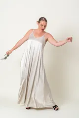 Vestido solera largo de viscosa, color dorado metalizado, con tirantes finos, escote en V y diseño amplio y acampanado.