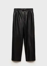 Pantalon tipo jogger de cuero sintético negro, con cintura elástica y cordón ajustable. Presenta un diseño de corte crop y costuras horizontales en la zona de las rodillas.