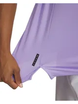 Remera deportiva de entrenamiento Under Armour, color lila, con diseño de ajuste cruzado en la cintura y cuello redondo. Confeccionada con tecnología UA RUSH™ que refleja la energía corporal, tejido elástico en cuatro direcciones y propiedades de secado rápido.