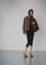 Chaqueta de diseño recto con estampado de pata de gallo, cuello alto y manga larga con puños elásticos. Cuenta con cierre delantero de cremallera y dos bolsillos con solapa en la parte delantera.