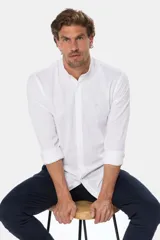 Camisa blanca de lino y algodón, de corte clásico, con cuello mao, mangas largas con puños abotonados y cierre frontal con botones.