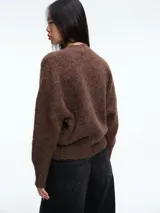 Sweater de tejido de punto con textura suave y acabado ligeramente afelpado, de corte holgado, cuello redondo y mangas largas.