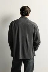 Camisa de hombre regular fit confeccionada en tejido fluido de viscosa gris, con cuello solapa, manga larga con puño abotonado y cierre frontal con botones.