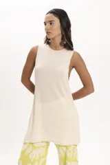 Blusa sin mangas color crema, de tejido de punto calado, con corte recto y cuello redondo.