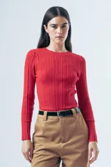 Top de tejido liviano con textura acanalada, de calce al cuerpo y manga larga con cuello redondo.
