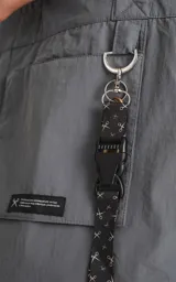 Bolso tipo tote bag de microfibra técnica color gris, con cordón ajustable con tanca. Posee un bolsillo externo con velcro y un bolsillo interno con cierre.