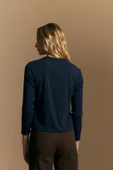 Remera de manga larga en color negro, con cuello redondo y costura vertical central en el frente. Presenta un diseño minimalista de calce ajustado y líneas limpias.