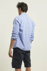 Camisa de manga larga color gris claro con textura, cuello abotonado y bolsillo en el pecho.