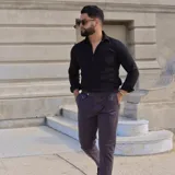 Pantalón de vestir color gris oscuro, con pinzas y bolsillos laterales.