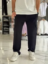 Pantalón jogging cargo color negro, sin felpa, liviano y de corte oversize, con bolsillos laterales en las piernas.