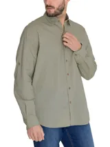 Camisa manga larga color verde oliva, confeccionada en popelina 100% algodón orgánico. Cuenta con cuello camisero, cierre frontal con botones de madera, bolsillo en el pecho con logo bordado y mangas ajustables con botones.