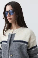 Cardigan de tejido jacquard en color azul marino y blanco, con diseño de conejitos en los laterales, cierre frontal con botones y cuello redondo.