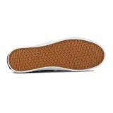 Zapatilla tipo slip-on de lona color azul marino, con suela de goma blanca y detalles en gris. Presenta un logo de velero en el talón y un detalle de costura ondulada en el empeine.