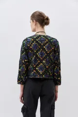 Saco corto negro con estampado geométrico de lentejuelas multicolor, cuello redondo y cierre frontal.