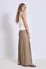 Pantalón palazzo color marrón claro, de tiro alto, con pinzas y bolsillos laterales.