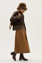 Bota tipo chelsea de cuero charolado color bordó, con caña media, elásticos laterales negros y taco cuadrado bajo.