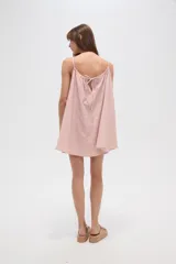 Vestido corto color rosa pálido con rayas verticales rojas, sin mangas, de corte ancho y cuello recto.