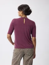 Remera de cuello redondo y manga corta, confeccionada en tejido de viscosa y poliéster, con un diseño básico y versátil.
