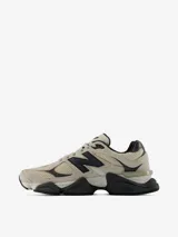 Championes urbanos New Balance modelo 9060, de color gris y beige con detalles en negro. Presentan un diseño robusto y futurista inspirado en la era Y2K, con entresuela gruesa esculpida y el característico logotipo "N" en el lateral.
