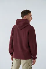 Buzo canguro color marrón de polar con capucha, bolsillo tipo canguro y logo estampado en el pecho.