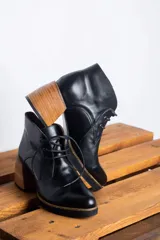 Botines acordonados de cuero negro con tacón de madera.